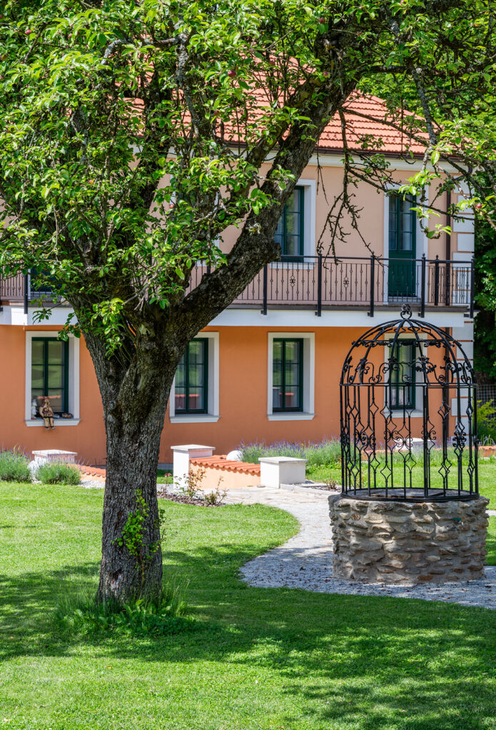 Strom a studna, na pozadí penzion